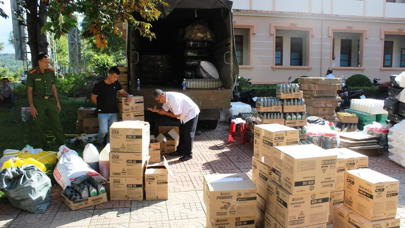 Lực lượng chức năng tổ chức kiểm đếm số lượng tang vật là dầu nhớt giả khi bị bắt.