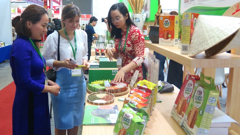 Khách tham quan, tìm hiểu sản phẩm tại một gian hàng thực phẩm tại Triển lãm.