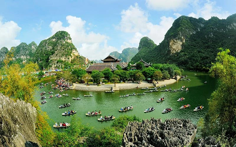 Du khách tham quan Di sản Văn hóa và Thiên nhiên thế giới Tràng An. (Ảnh NINH MẠNH THẮNG) 
