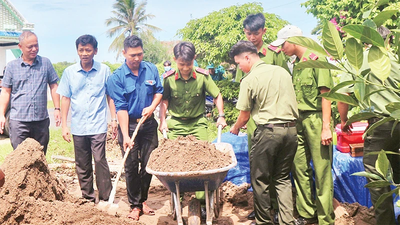 Lực lượng Công an tỉnh Sóc Trăng giúp đỡ xây dựng nhà cho các hộ nghèo. 