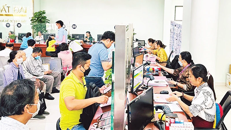 Cán bộ Văn phòng đăng ký đất đai thành phố Thủ Ðức làm thủ tục hồ sơ nhà đất cho người dân. 