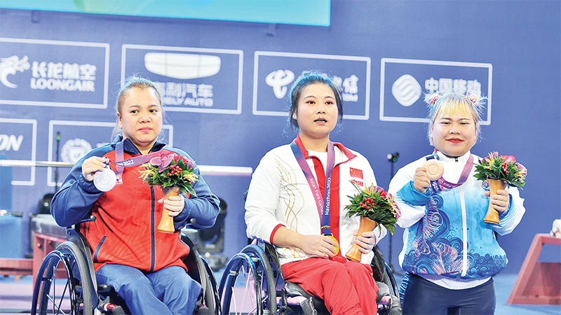 Lực sĩ Ðặng Thị Linh Phượng (ngoài cùng, bên trái) nhận HCB môn cử tạ. (Ảnh THÁI DƯƠNG)