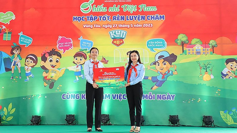 Đồng chí Nguyễn Phạm Duy Trang, Bí thư Trung ương Đoàn, Chủ tịch Hội đồng Đội Trung ương (bên phải) trao biển tượng trưng công trình "Không gian vui chơi và đọc sách cho em" tặng đại diện Hội đồng Đội tỉnh Bà Rịa-Vũng Tàu. 