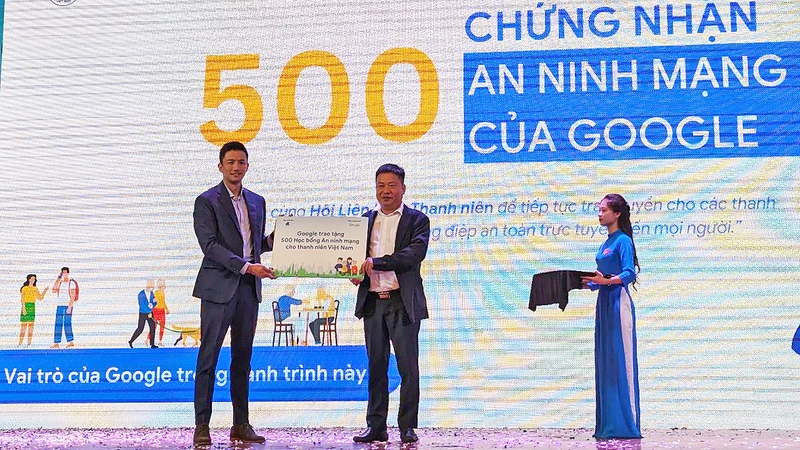 Giám đốc điều hành phụ trách Việt Nam tại Google châu Á-Thái Bình Dương Marc Woo (bên trái) trao biển tượng trưng 500 học bổng an ninh mạng tặng thanh niên Việt Nam.