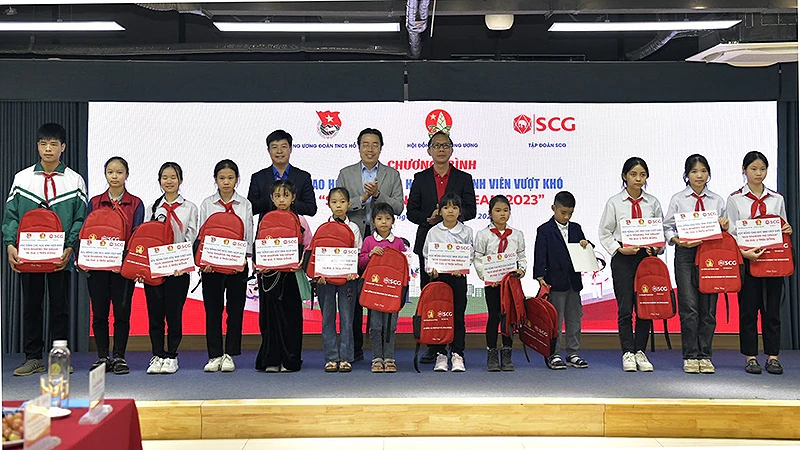 Đại diện Ban tổ chức và các bộ, ngành liên quan trao học bổng tặng học sinh có hoàn cảnh khó khăn tại chương trình. 