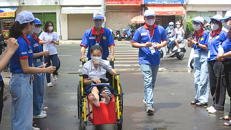 Lực lượng tình nguyện viên "Tiếp sức mùa thi" tại Thành phố Hồ Chí Minh hỗ trợ thí sinh đến phòng thi an toàn.