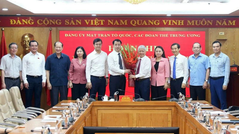 Đồng chí Đỗ Văn Chiến (thứ 5 từ phải sang) và đại diện các ban, ngành, đoàn thể tặng hoa chúc mừng Phó Bí thư chuyên trách Đảng ủy Mặt trận Tổ quốc, các đoàn thể Trung ương Ngô Văn Cương.