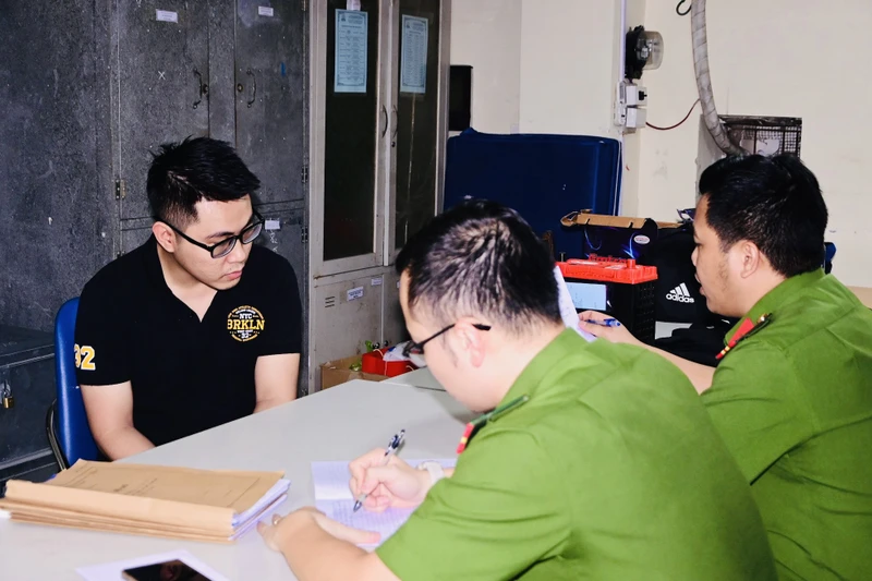 Nguyễn Tường Lâm (áo đen) bị bắt giữ tại cơ quan công an.