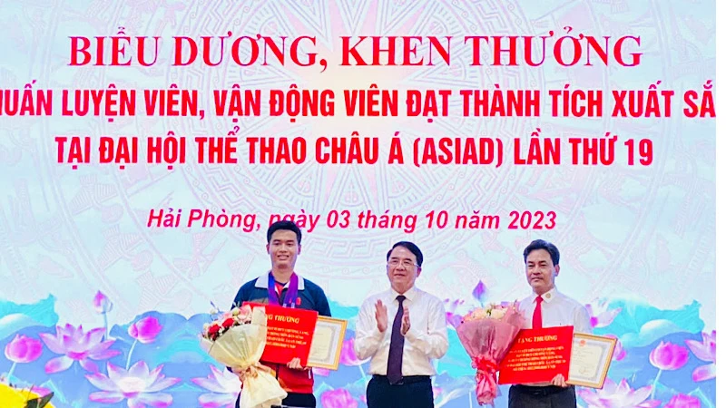 Lãnh đạo Ủy ban nhân dân thành phố Hải Phòng trao Bằng khen và tiền thưởng tặng vận động viên Phạm Quang Huy (trái) và huấn luyện viên Phạm Cao Sơn (phải).