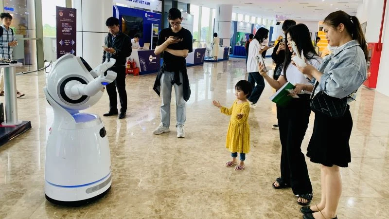 Người dân bị thu hút bởi rô-bốt tại một sự kiện về đổi mới sáng tạo Việt Nam. (Ảnh: HNV)
