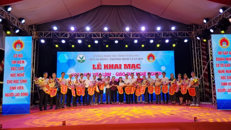 Trao cờ và quà lưu niệm cho các doanh nghiệp, đơn vị tư vấn việc làm.