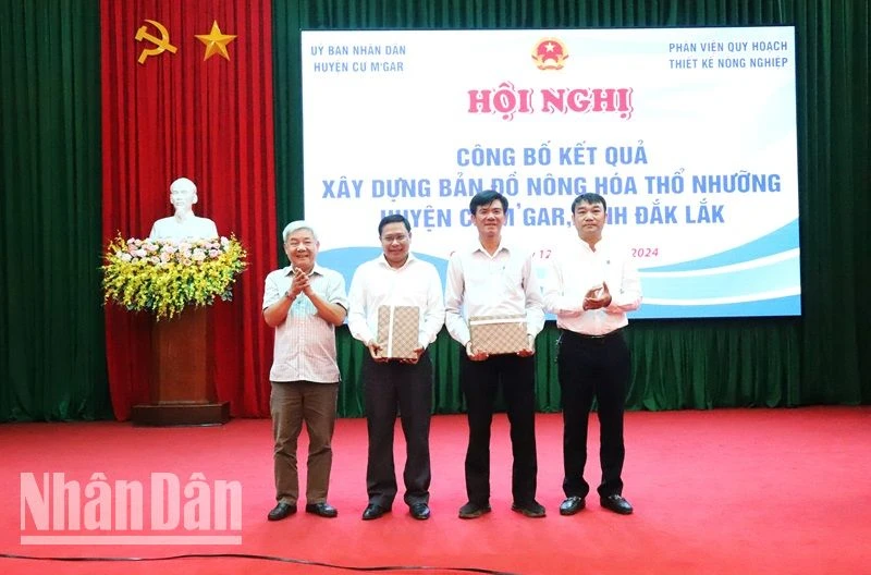 Lãnh đạo Phân viện quy hoạch và thiết kế nông nghiệp thuộc Bộ Nông nghiệp và Phát triển Nông thôn trao bản đồ nông hóa thổ nhưỡng trên địa bàn huyện cho lãnh đạo Ủy ban nhân dân huyện Cư M'gar.