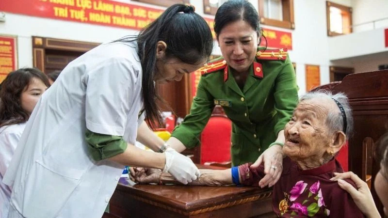 Cán bộ, chiến sĩ Công an và nhân viên Công ty GeneStory tiến hành thu nhận mẫu ADN mẹ liệt sĩ. (Ảnh: Công an tỉnh Đắk Lắk)