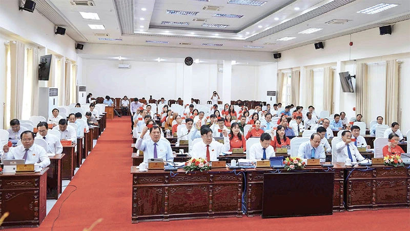 Đại biểu Hội đồng nhân dân tỉnh Cà Mau biểu quyết thông qua Nghị quyết về Đề án hợp nhất tỉnh Cà Mau và Bạc Liêu thành tỉnh Cà Mau.