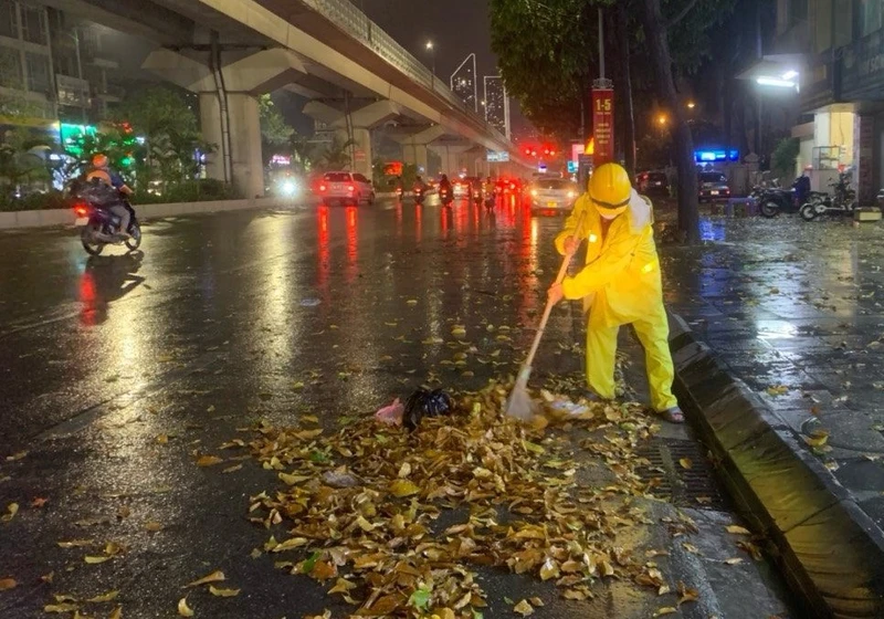 Công nhân Công ty Thoát nước Hà Nội thu dọn rác tại các cửa cống. 