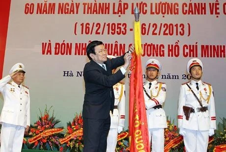 Chủ tịch nước Trương Tấn Sang gắn Huân chương Hồ Chí Minh lên Cờ truyền thống của Lực lượng Cảnh vệ Công an nhân dân. 