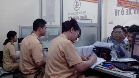 Cán bộ tiếp nhận hồ sơ đăng ký ô-tô tại cơ sở đăng ký xe số 1 (quận Hoàn Kiếm, Hà Nội).