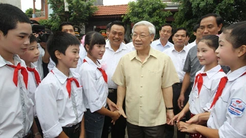 Tổng Bí thư Nguyễn Phú Trọng với các cháu thiếu nhi thôn Dưới, xã Cảnh Thụy, huyện Yên Dũng. Ảnh: Trí Dũng (TTXVN)