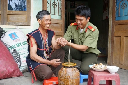 Già làng A Nguyh cùng khách bên ghè rượu cần. 