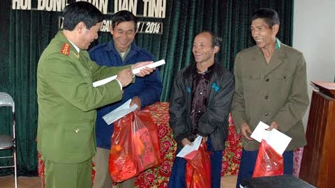 Đại tá Lê Văn Bảy trao quà tặng cho các già làng trưởng bản ở Tà Tổng, những người có tác động tích cực rất lớn đối với cộng đồng về việc cai nghiện và xóa cây thuốc phiện.