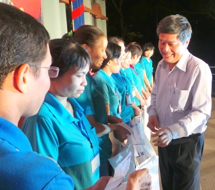 Đại diện Thành ủy TP Hồ Chí Minh trao quà và vé xe cho công nhân.