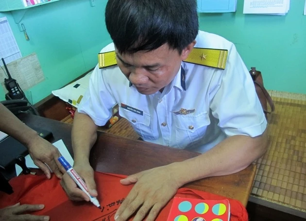 Trạm trưởng Nguyễn Văn Đồng ghi tặng lá cờ của nhà giàn Huyền Trân cho đoàn công tác.