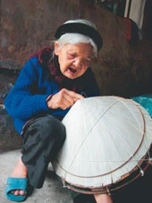 Cụ bà Lê Thị Ngấn, gần 80 tuổi vẫn ngồi khâu nón.