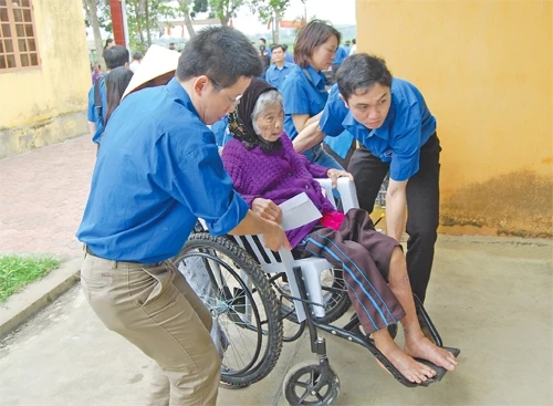 Đoàn viên thanh niên Đoàn Khối các cơ quan trung ương giúp đỡ người già khám, chữa bệnh tại huyện Thanh Chương (Nghệ An).