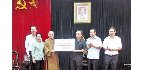 Hòa thượng Thích Thiện Tánh thay mặt Ban Trị sự Giáo hội Phật giáo TP Hồ Chí Minh trao (tượng trưng) 60 căn nhà Ðại đoàn kết tặng nhân dân tỉnh Ðiện Biên.