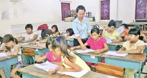 Đảng viên trẻ Nguyễn Thị Ngọc Hân tận tình chỉ bảo các em tại lớp học tình thương ở khu phố 2, phường 10, quận 6.