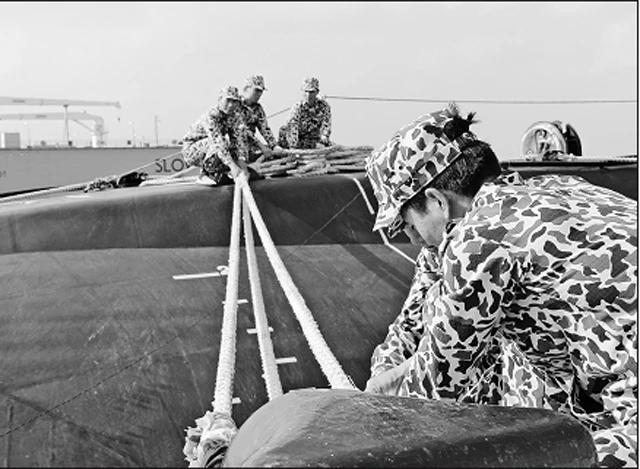 Kíp tàu ngầm HQ-182 Hà Nội huấn luyện làm dây an toàn cho tàu tại cầu cảng.