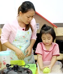 Dạy con làm việc nhà. Ảnh: THĂNG LONG