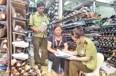 Các hộ kinh doanh tại chợ Đồng Xuân ký cam kết kinh doanh hàng hóa có nguồn gốc rõ ràng với Đội Quản lý thị trường số 2. Ảnh: ĐỨC DUY