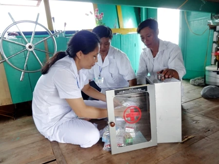 Cán bộ y tế xã Cẩm Nhượng, Cẩm Xuyên (Hà Tĩnh) hướng dẫn ngư dân sử dụng thuốc và dụng cụ y tế cấp cứu ban đầu.