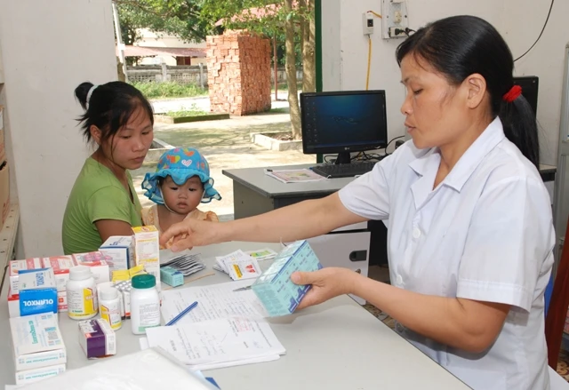 Cấp phát thuốc BHYT cho người bệnh tại Trạm y tế xã Tiến Xuân (Thạch Thất, Hà Nội).
