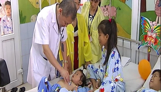PGS.TS Lê Ngọc Thành đang khám lại cho bệnh nhi vừa được phẫu thuật.