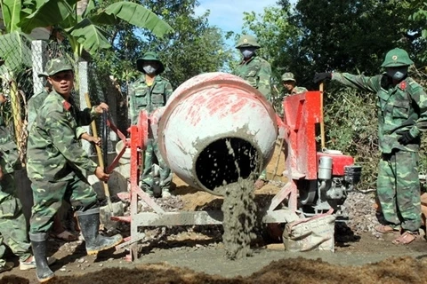 Cán bộ, chiến sĩ LLVT tỉnh Bình Ðịnh giúp người dân xã Cát Tài, huyện Phù Cát làm đường giao thông nông thôn.   Ảnh: ÐỨC DŨNG