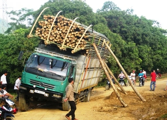 Ô-tô tải chở lâm sản cồng kềnh bị nghiêng, gây ách tắc giao thông.