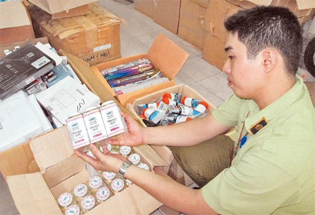 Cán bộ Chi cục Quản lý thị trường thành phố Hồ Chí Minh thu giữ lô hàng không rõ nguồn gốc, xuất xứ lưu hành trên thị trường. Ảnh: Minh Thoa