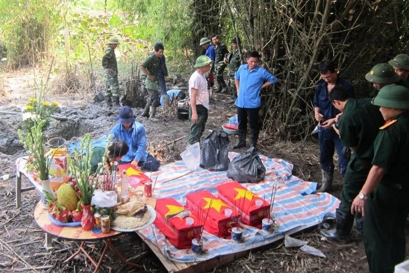 Lực lượng chức năng cất bốc phần mộ, hài cốt các liệt sĩ.