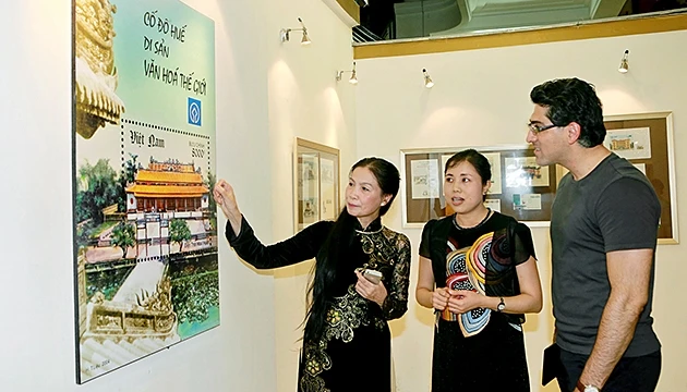 Nữ hoạ sĩ Hoàng Thuý Liệu (bên trái) giới thiệu các tác phẩm với khách thăm quan.
