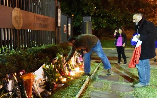 Người đàn ông đặt hoa trước Đại sứ quán Pháp tại Washington D.C (Mỹ) để tưởng nhớ nạn nhân trong vụ tấn công khủng bố tại Paris. (Ảnh: Tân Hoa xã) 