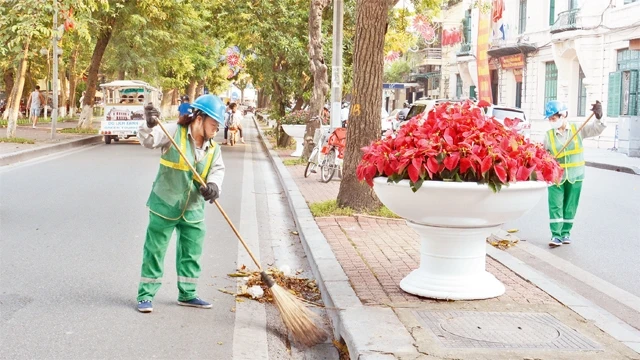 Công nhân Công ty Môi trường đô thị làm sạch đẹp đường phố Thủ đô. Ảnh: NGỌC MAI