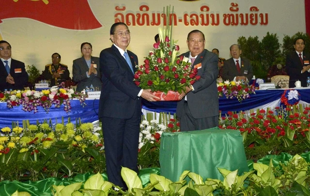 Nguyên Tổng Bí thư Chum-ma-ly Xay-nha-xỏn (người đứng bên trái) chúc mừng Tổng Bí thư Bun-nhăng Vo-la-chít .  Ảnh: PHẠM KIÊN (Phóng viên TTXVN tại Lào)