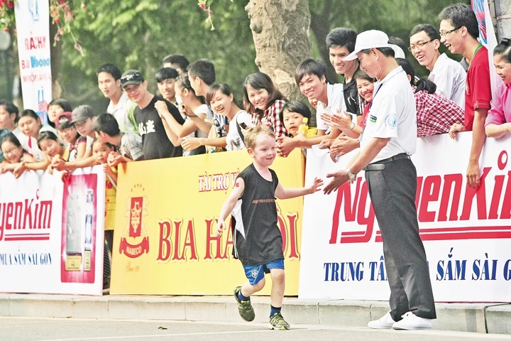 Em bé nước ngoài được chào đón và cổ vũ khi tham gia một sự kiện thể thao quốc tế tại Hà Nội. Ảnh: Minh Lê