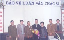Ông Lâm Nguyên Kỳ (người thứ ba từ trái sang) trong lễ bảo vệ luận văn thạc sĩ của con trai, anh Lâm Văn Cấp (người cầm 