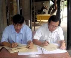 Nhà thơ Trương Nam Hương (trái) và nhà văn Nguyễn Nhật Anh đang viết thơ trên giấy dó.