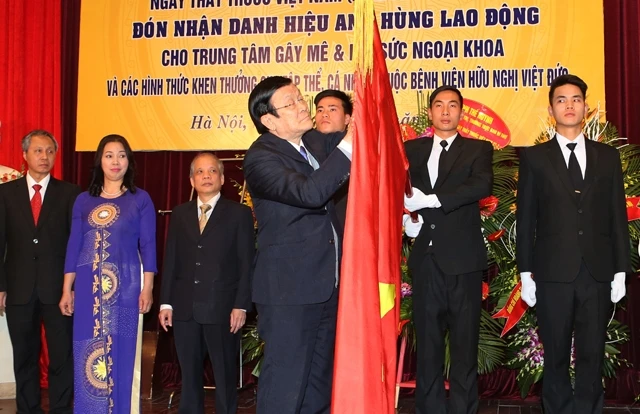 Chủ tịch nước Trương Tấn Sang gắn danh hiệu Anh hùng Lao động lên lá cờ truyền thống của Trung tâm Gây mê và hồi sức ngoại khoa. 