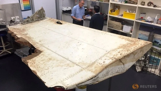 Các chuyên gia Australia và Malaysia kiểm tra mảnh vỡ máy bay tại trụ sở Cục An toàn giao thông vận tải Australia (ATSB), ở Canberra, Australia, sau khi mảnh vỡ này được tìm thấy tại đảo Pemba, gần Ta