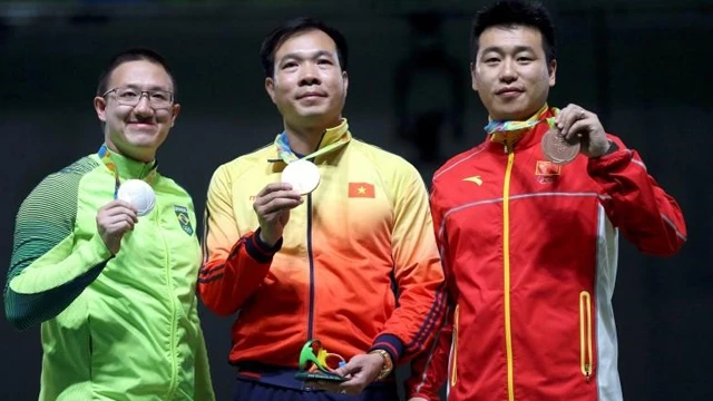 Hoàng Xuân Vinh (ở giữa) trên bục nhận huy chương. (Ảnh: Reuters)